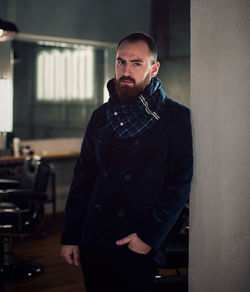 Portrait of mid adult bearded man standing in hair salon