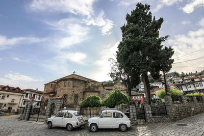 Cars in city against sky