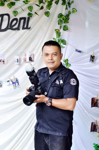 Portrait of young man holding camera