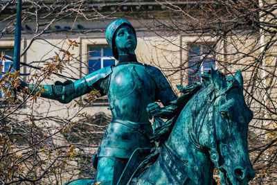 Low angle view of statue against bare trees