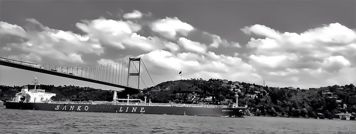 Suspension bridge against cloudy sky