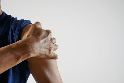 Low section of man holding hands against white background