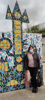 Full length of woman standing against graffiti