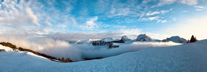 Panoramic view of snow covered mountains against sky