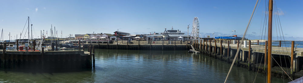 Sailboats moored at harbor against sky