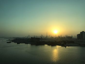 View of city at waterfront during sunset