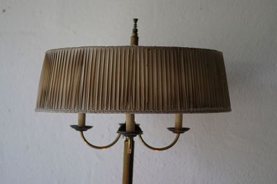 Close-up of electric lamp on table against wall