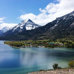 Scenic view of lake by snowcapped mountains against sky