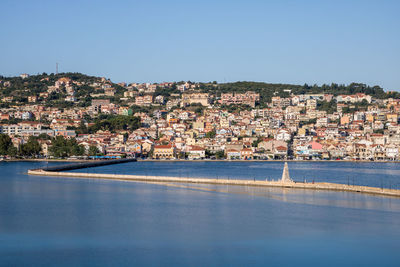 Aerial view of townscape by sea against clear sky