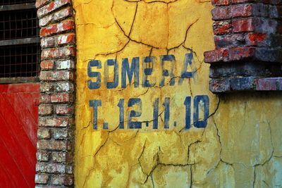 Close-up of text on yellow wall