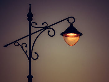 Low angle view of illuminated lamp post against sky at night