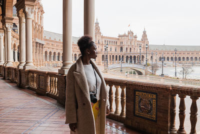 Full length of woman standing at historical building