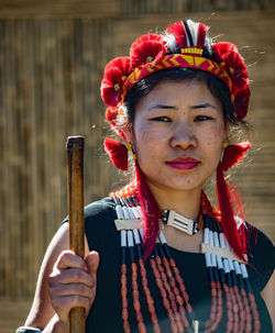 Close-up portrait of woman with arms raised standing outdoors