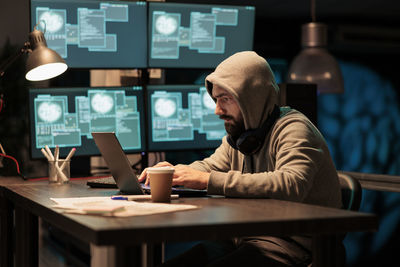 Rear view of woman using laptop on table