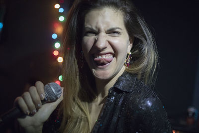 Young woman singing at band rehearsal