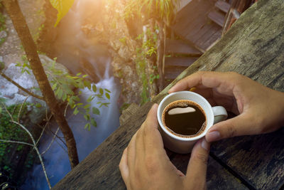 High angle view of hand holding coffee cup