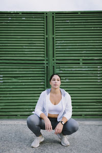 Full length of young woman sitting outdoors