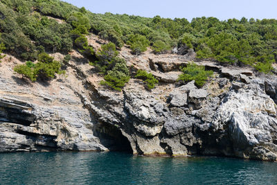 Rock formations by sea against sky