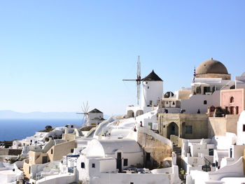 Buildings in town against clear blue sky