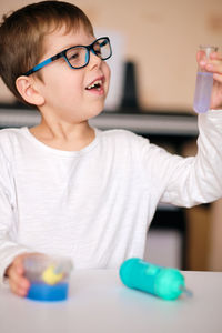 Boy is engaged in scientific research. a child with a test tube and a pipette in his hands. 