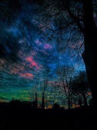 Silhouette of trees against cloudy sky