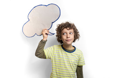 Full length portrait of boy standing against white background