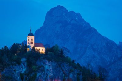 Low angle view of building and mountains against blue sky