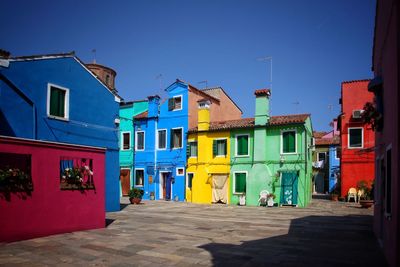 Multi colored houses against clear blue sky