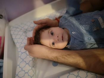 Portrait of cute baby lying on bed at home