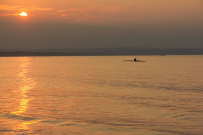 Scenic view of sea against orange sky