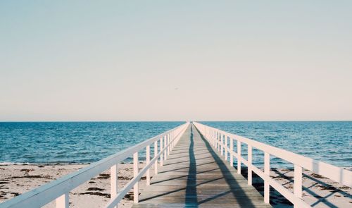 Pier over sea against clear sky