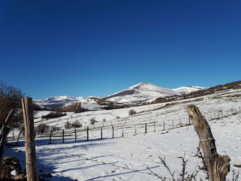 Scenic view of snowcapped mountains against clear blue sky