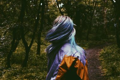 Rear view of woman standing in forest