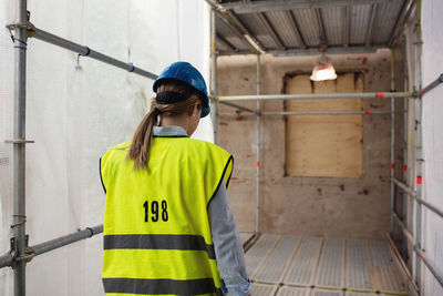 Rear view of female manager walking at construction site