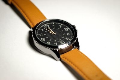 Close-up of clock on table against white background