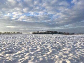 Snow covered land against sky