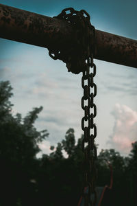 Close-up of rusty chain against sky