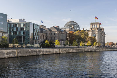 Bridge over river against buildings in city