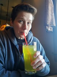 Portrait of woman drinking juice at restaurant