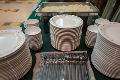 Close-up of stacked plates and cutlery on table