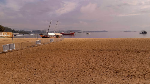 Sailboats on beach against sky