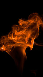 Close-up of orange smoke against black background