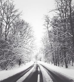 Snow covered road passing through landscape