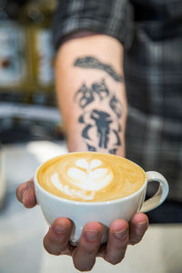 Cropped image of hand holding coffee cup