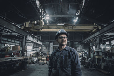 Male worker looking away while standing in metal industry