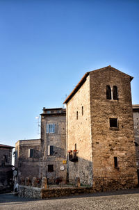 Low angle view of old building against clear blue sky