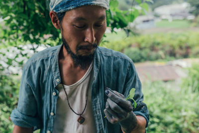 Man looking at plant