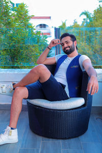 Portrait of young man sitting on plant