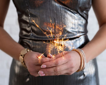 Midsection of woman holding sparkler