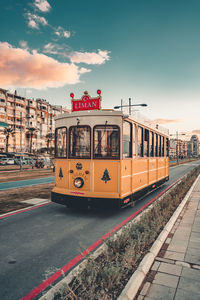 Train on railroad tracks in city against sky